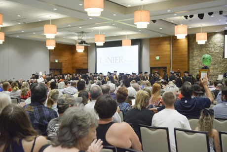 Photo of graduates waving to the audience.