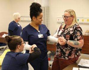 Brenda Falck assisting students at Lanier Tech as a CNA Lab Assistant.