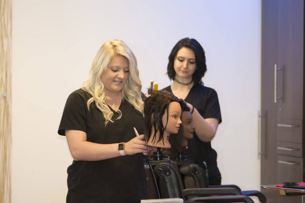 Cosmetology students cutting hair.