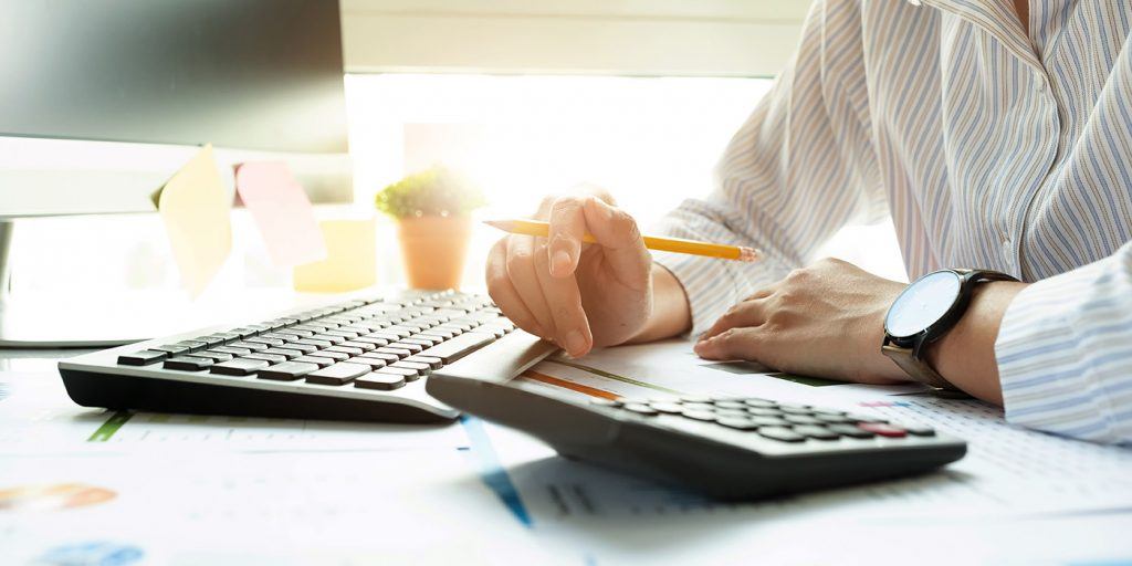 CLoseup of keyboard, calculator and hands