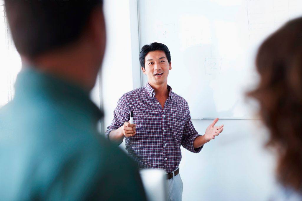 An associate giving a presentation using a whiteboard