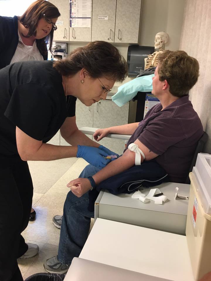 Students taking blood from patient.