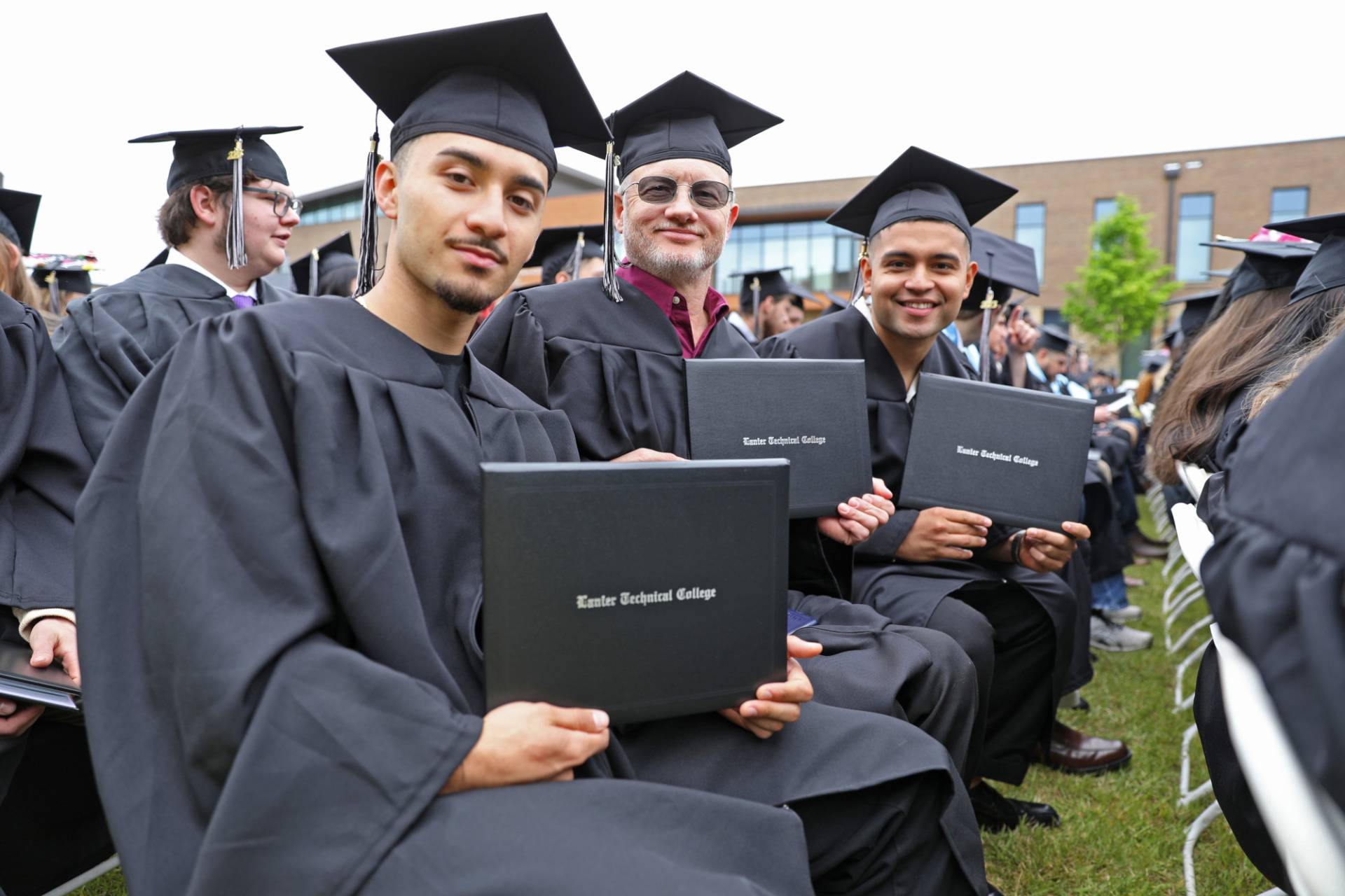 Graduates holding diplomas