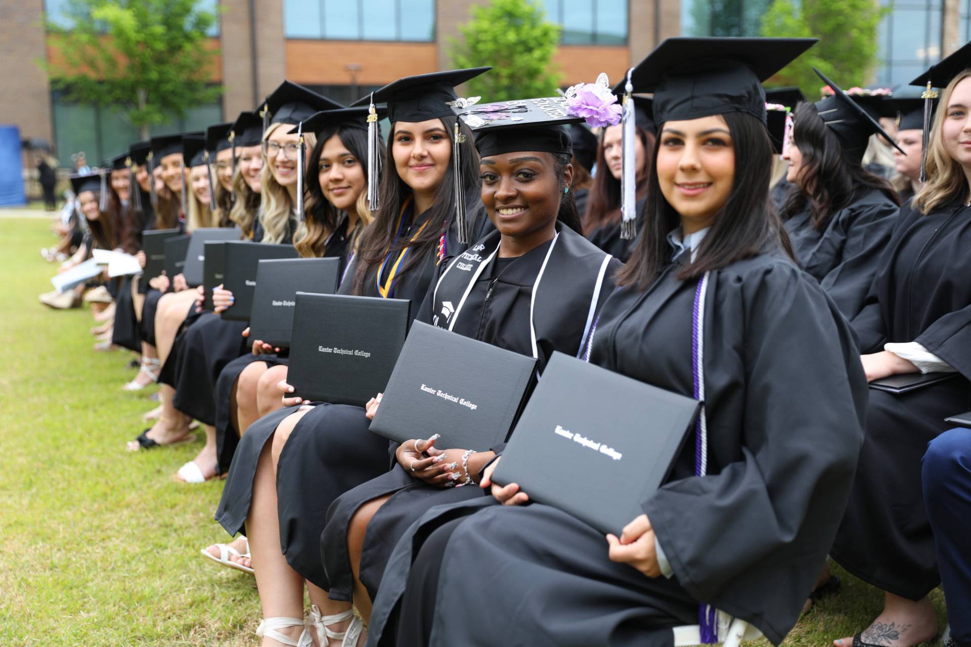 graduates holding diplomas